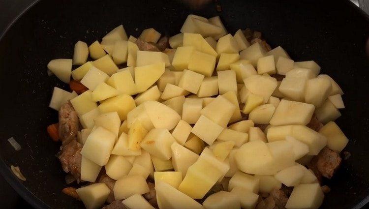 legen Sie die Kartoffeln auf das Fleisch, aber mischen Sie nicht.