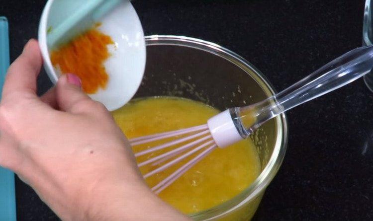 Разбийте яйцата със захарта и добавете портокалова кора.