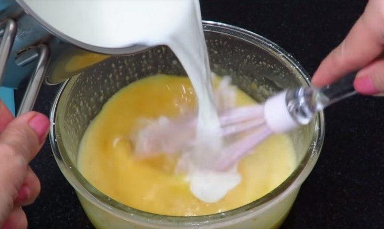 يتم إدخال جزء من الحليب الساخن في كتلة البيض.