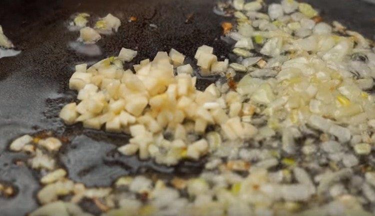 friggere le cipolle con l'aglio in una padella.