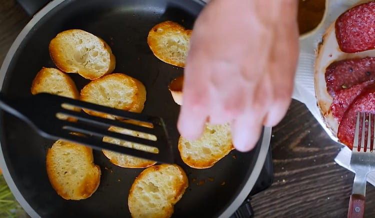 Friggere le fette di baguette francese in una padella.