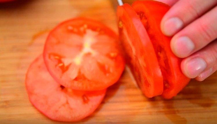 leikkaa tomaatit ympyröiksi.