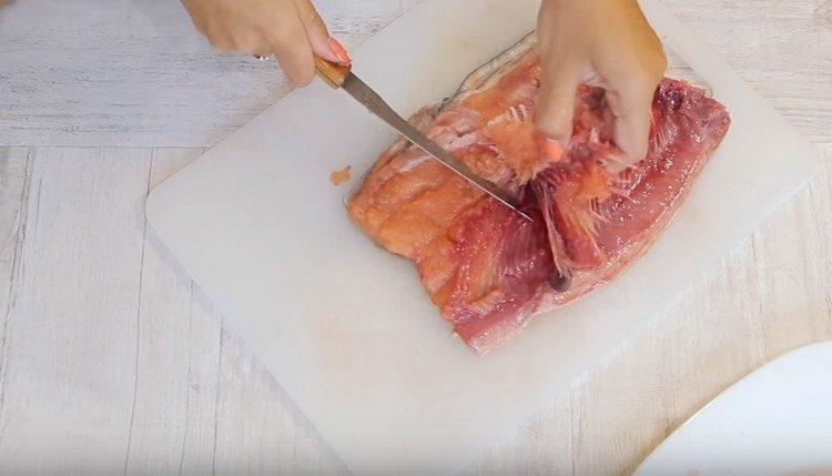 Tagliamo il salmone rosa in filetti, rimuoviamo le ossa.