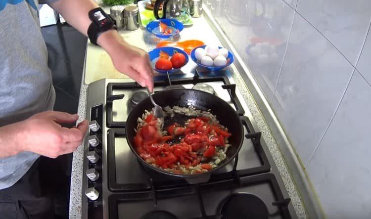 Fügen Sie die geschnittenen Tomaten der Zwiebel hinzu.