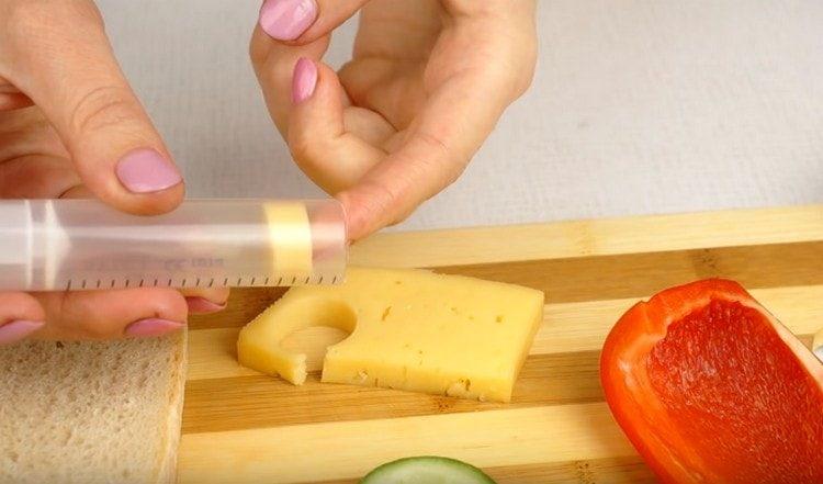 Vytlačte kruh z plátku sýru injekční stříkačkou.
