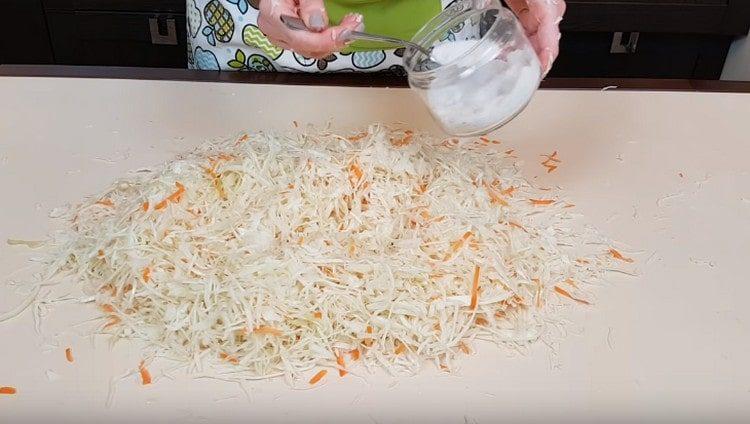 Į kopūstą su morkomis įpilkite druskos.