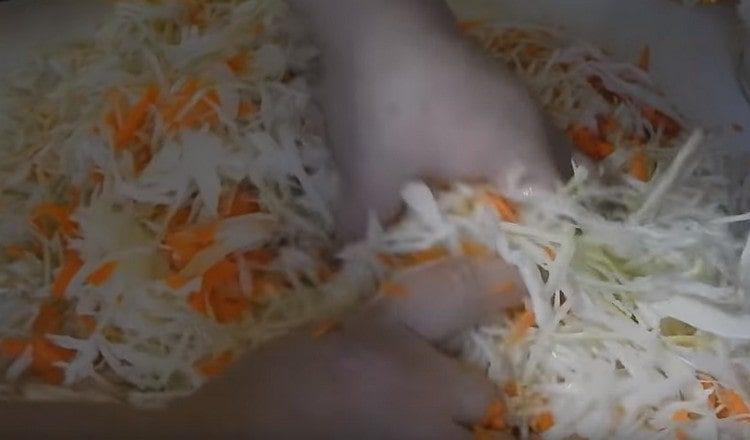 Смесваме зелето с морковите и омесваме с ръце.