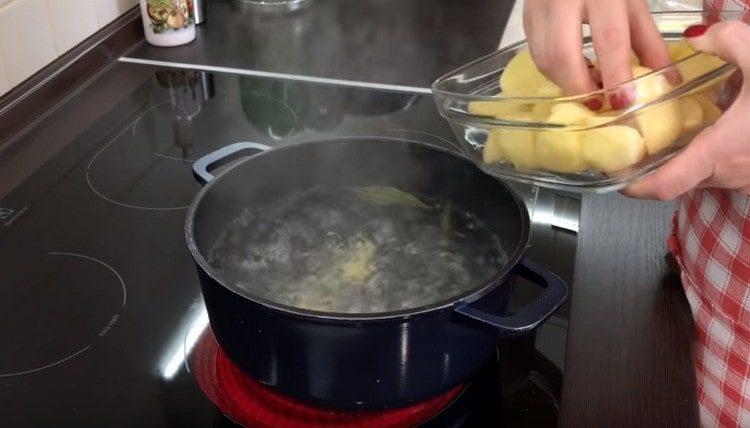 Puhdistamme perunat, leikataan ne paloiksi ja laitetaan keitettyyn veteen.