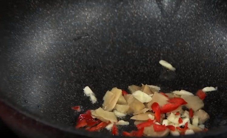 In einer Pfanne eine Mischung aus Ingwer, Knoblauch und Chili in Öl anbraten.