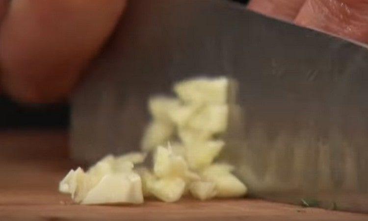Macina l'aglio con un coltello.