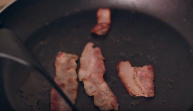 Smažte tenké plátky slaniny na pánvi.