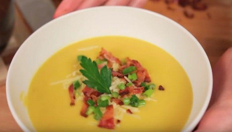 Servi la classica purea di zuppa di zucca, decorandola con pancetta e cipolle verdi.