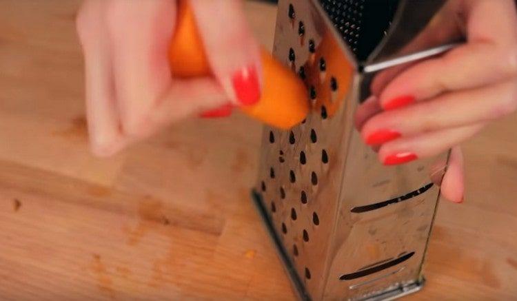 Reiben Sie die Karotten auf einer Reibe.
