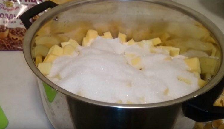 Distribuiamo i pezzi di zucca in una padella, aggiungiamo lo zucchero.