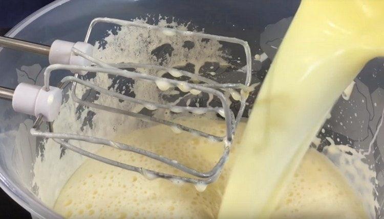 Aggiungi il latte leggermente raffreddato e il burro alla massa di uova.