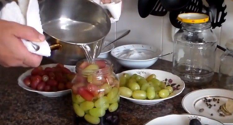 Изсипете гроздето в буркани с вряла вода.