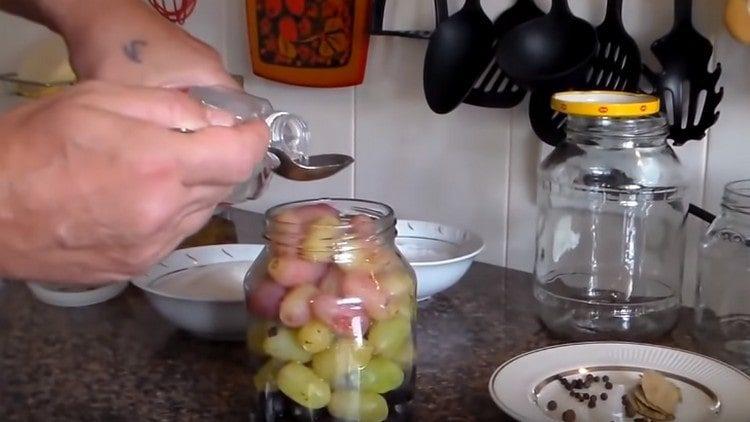Aggiungi aceto al barattolo di uva.