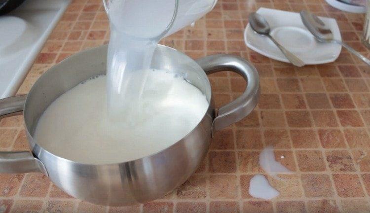 Изсипете мляко и вода в тигана.