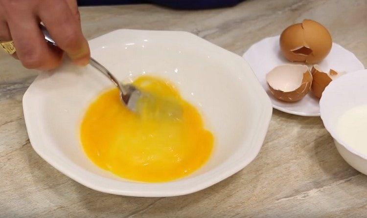 Eier mit einer Gabel leicht schlagen.