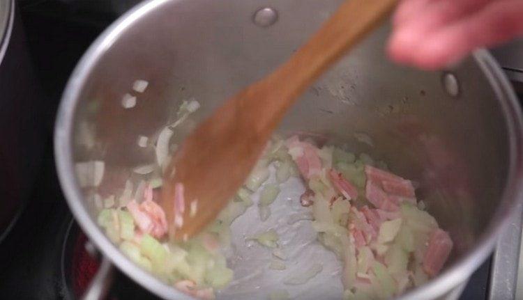 Přidejte do cibule česnek a slaninu s celerem.