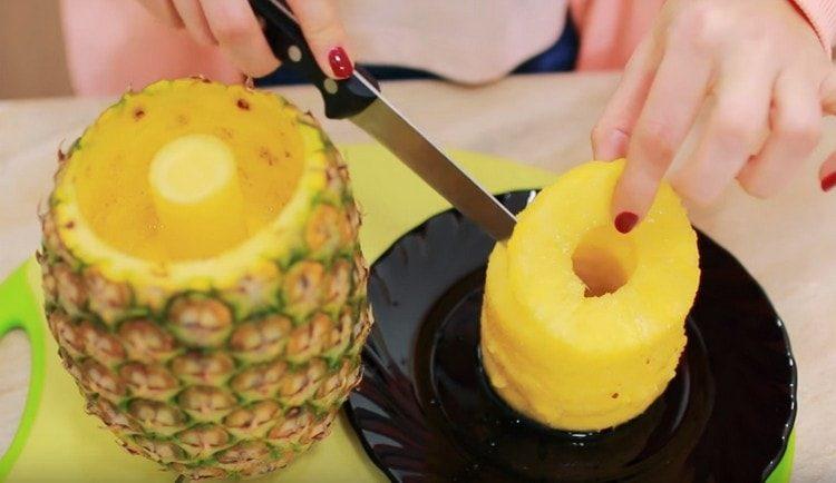 Taglia un cerchio di ananas e distribuiscilo in una ciotola del frullatore.