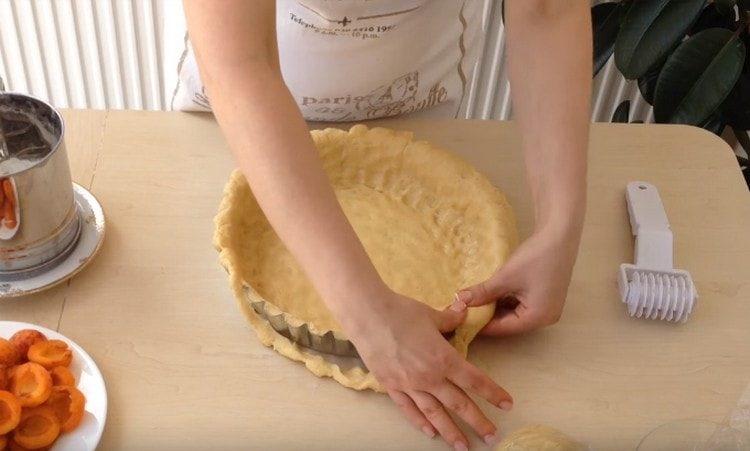 Iš didžiosios dalies tešlos formuojame pyrago dugną ir šonus.