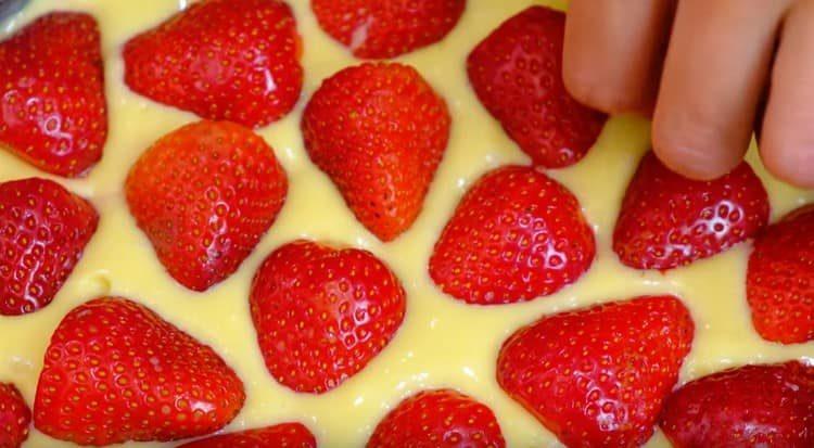 Die Oberseite des Kuchens wird mit Hälften der Erdbeeren verziert.