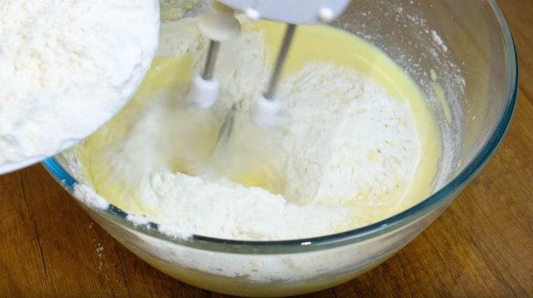 Изсипете брашно в тестото на части.