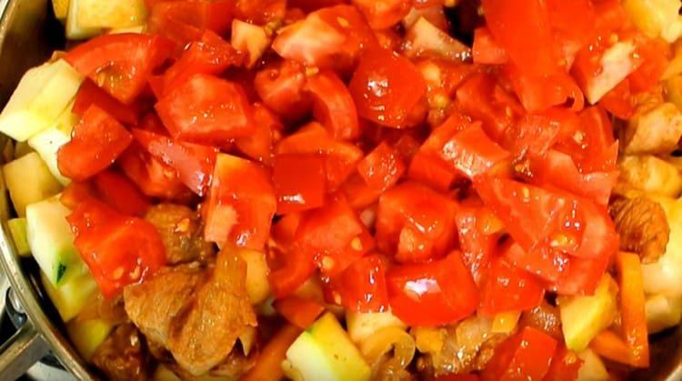 Do dušeného masa přidejte nakrájená rajčata.