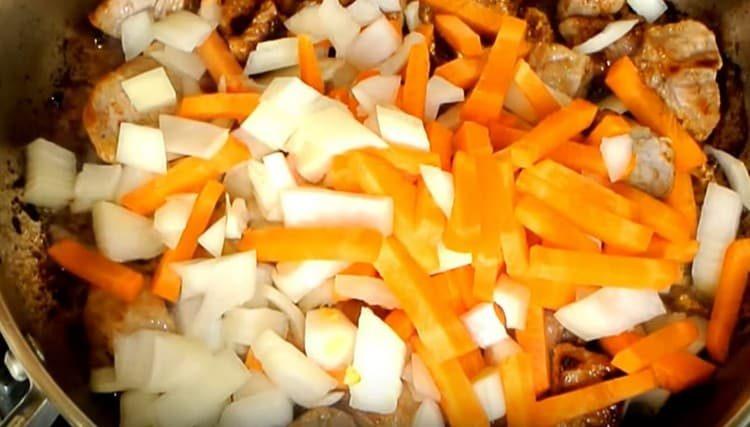 Aggiungi carote e cipolle alla carne.