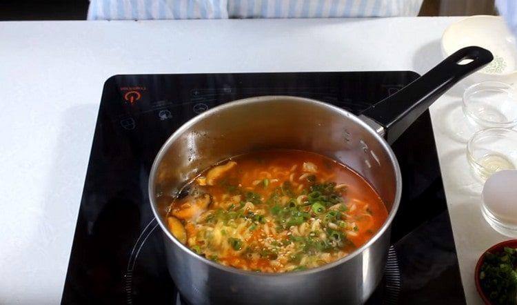 يُضاف البصل الأخضر المفروم إلى الحساء.