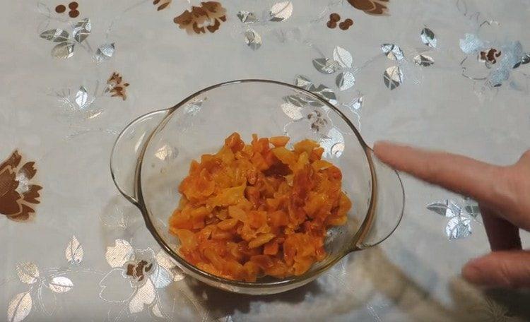 Getrocknete, mit kochendem Wasser gedämpfte Aprikosen in Stücke schneiden.