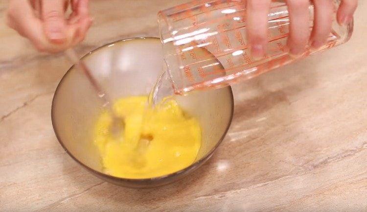 Προσθέστε νερό και αναμίξτε τη μάζα των αυγών.