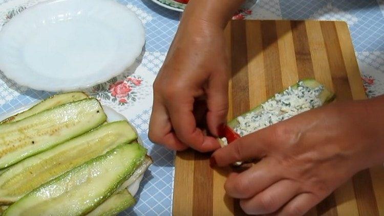Lubrificare le zucchine con il ripieno, distribuire la fetta di pomodoro.
