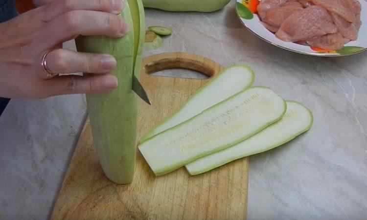 Zucchini in dünne Teller schneiden.