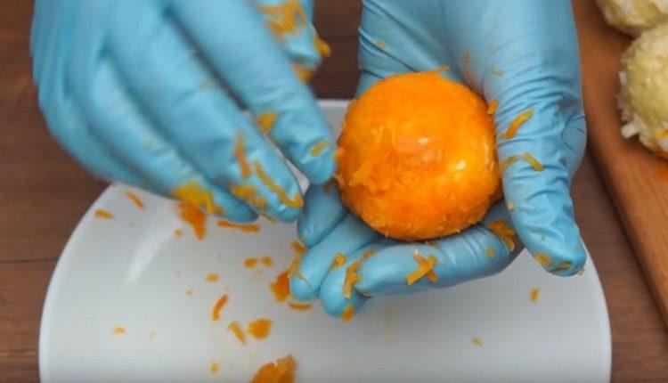 Rotolare un'altra porzione di palline in carote.