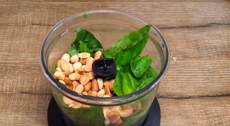 Metti le arachidi e le foglie di basilico in un frullatore.