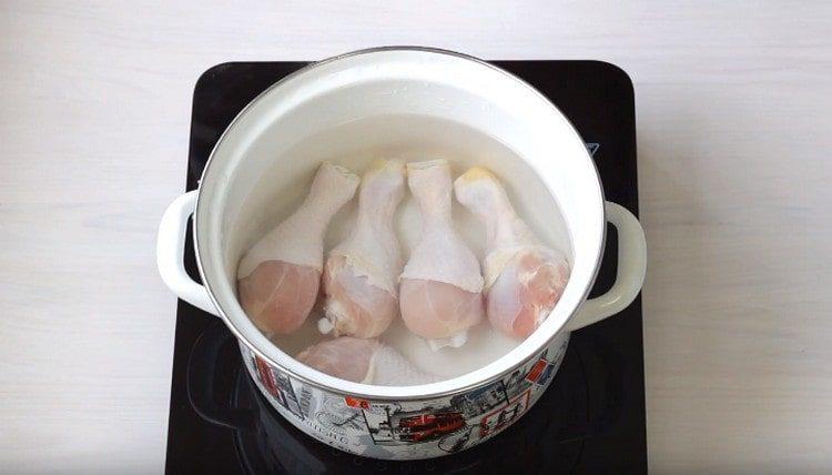 Distribuiamo le cosce di pollo nella padella, riempiamole con acqua.