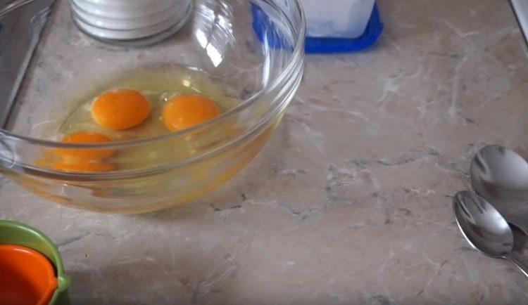 mušti kiaušinius į dubenį, kad būtų paruošta tešla.