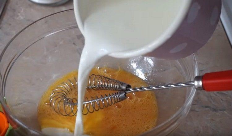 Į kiaušinių masę supilkite dalį pieno.