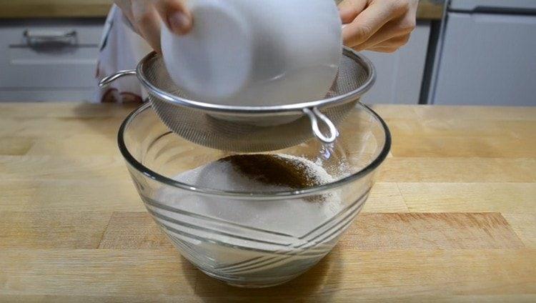 Пресейте брашното, добавете към него захар, ванилова захар, бакпулвер и какао.