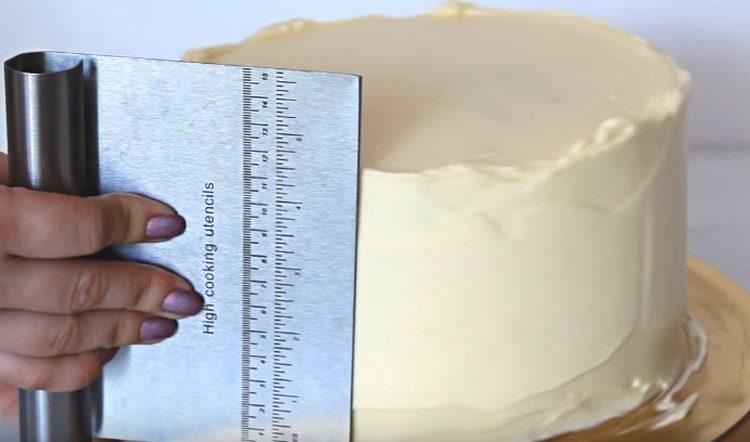 Το μουσκεμένο κέικ επιστρώνεται και πάλι με κρέμα, οριζοντίζοντας την επιφάνεια.