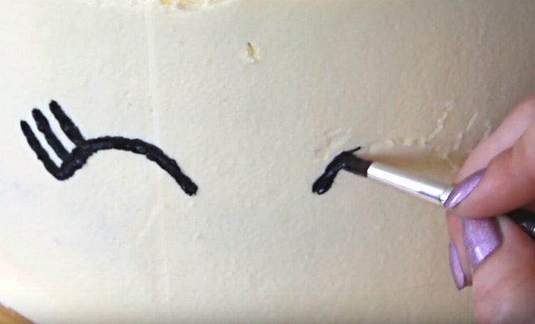 U černého potravinářského barvení kreslíme na dort oči jednorožce.