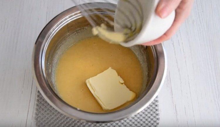 Fügen Sie die Butter der Masse hinzu und legen Sie sie auf das Feuer.