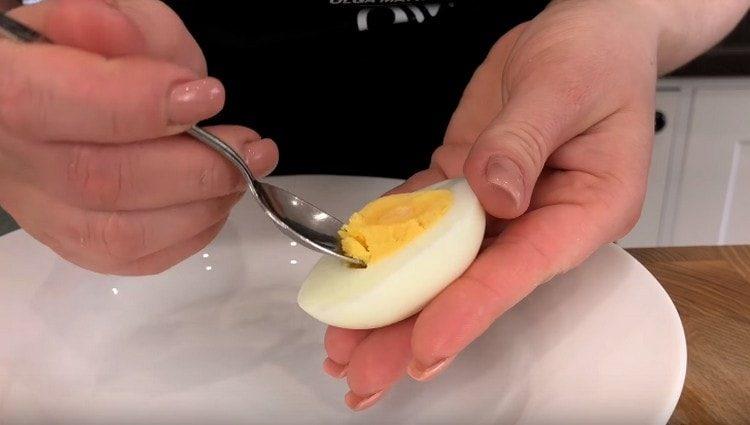 kiaušinius perpjaukite per pusę ir atsargiai išimkite trynį.