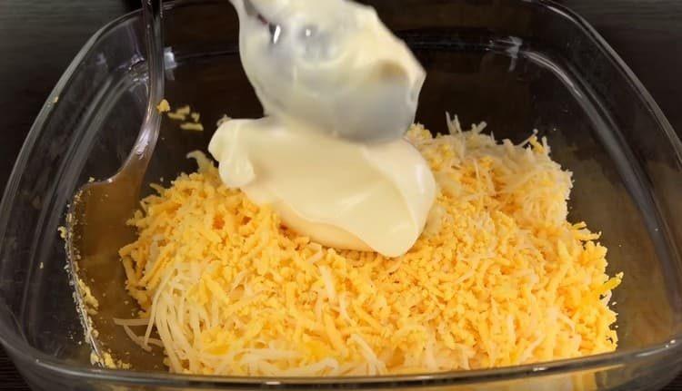 Į sūrį su tryniais įpilkite majonezo ir česnako.