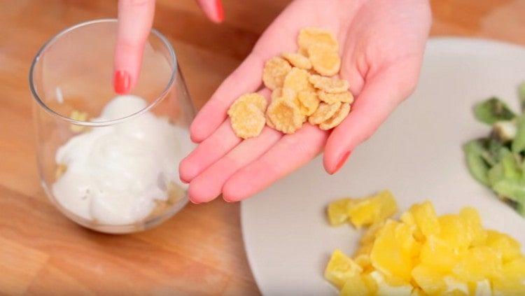 streuen Sie ein paar Cornflakes auf den Joghurt.