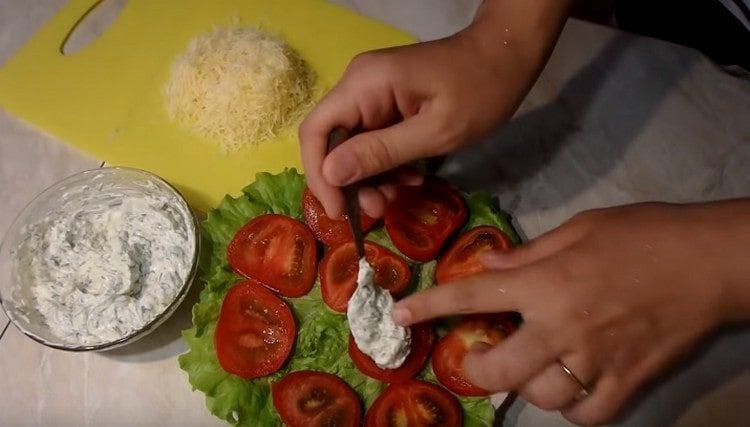Verteilen Sie jeden Tomatenkreis mit Mayonnaise-Knoblauch-Mischung.
