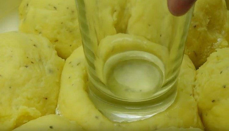 Se sklenicí v každé bramborové kouli vytvoříme prohlubeň.