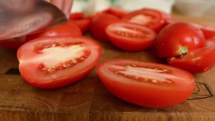 Schneiden Sie die Tomaten in zwei Hälften